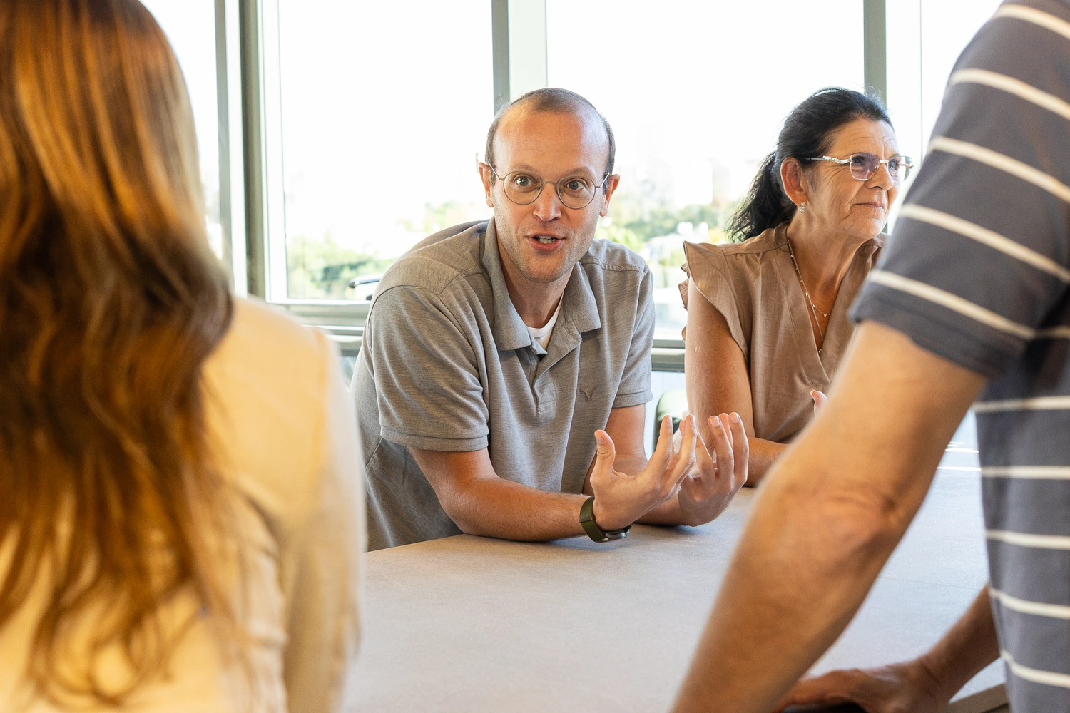 A colleague making a point across the meeting table.