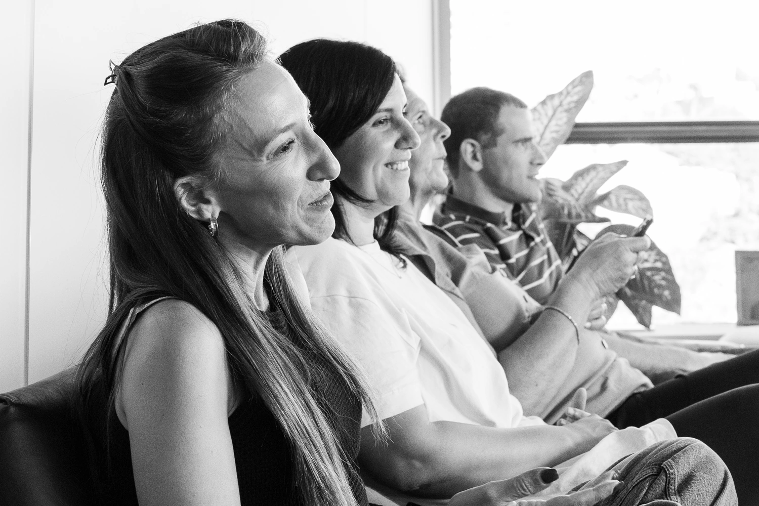 Colleagues seated in a row along the window, listening.